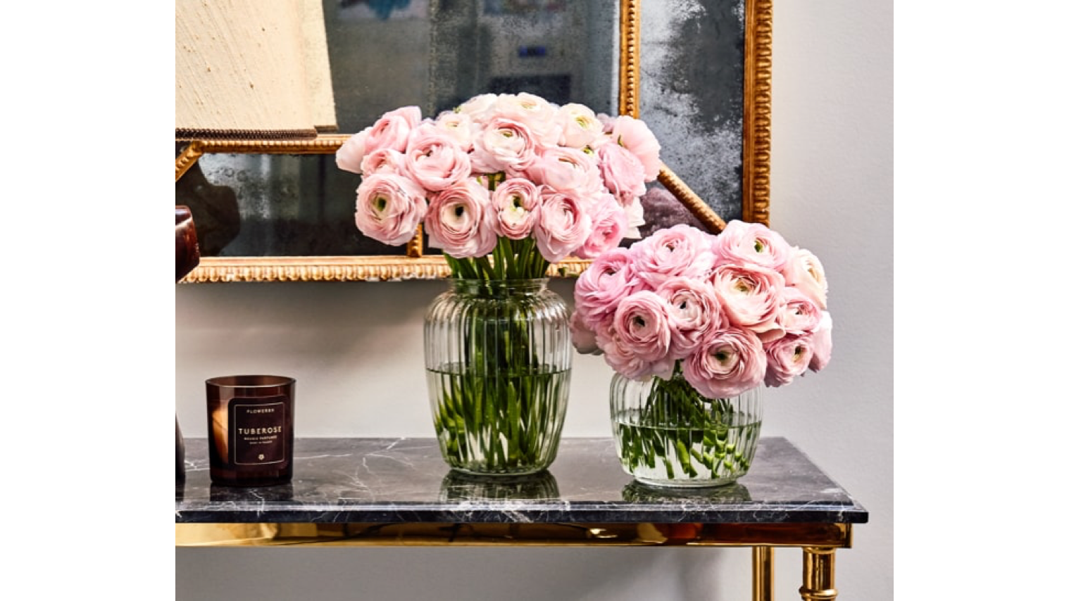 Two vases of roses on a hall table.