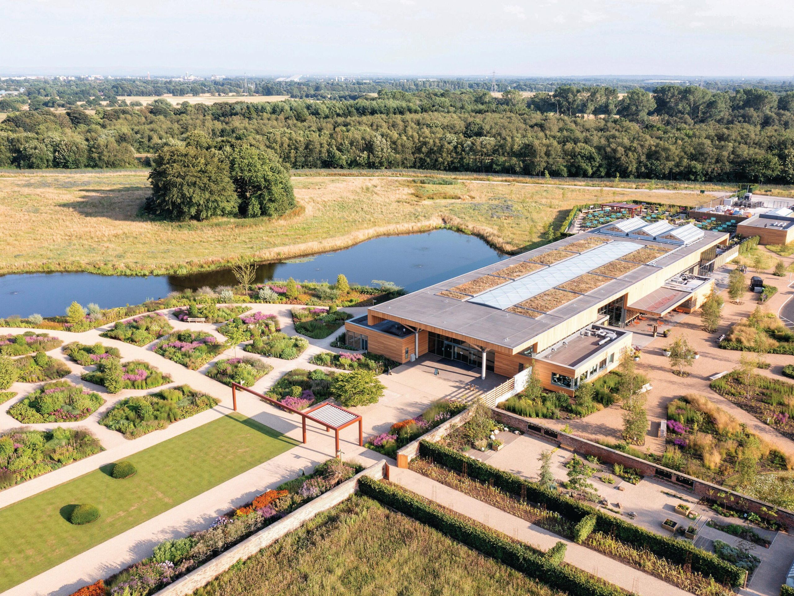Aerial view of garden, building and pond