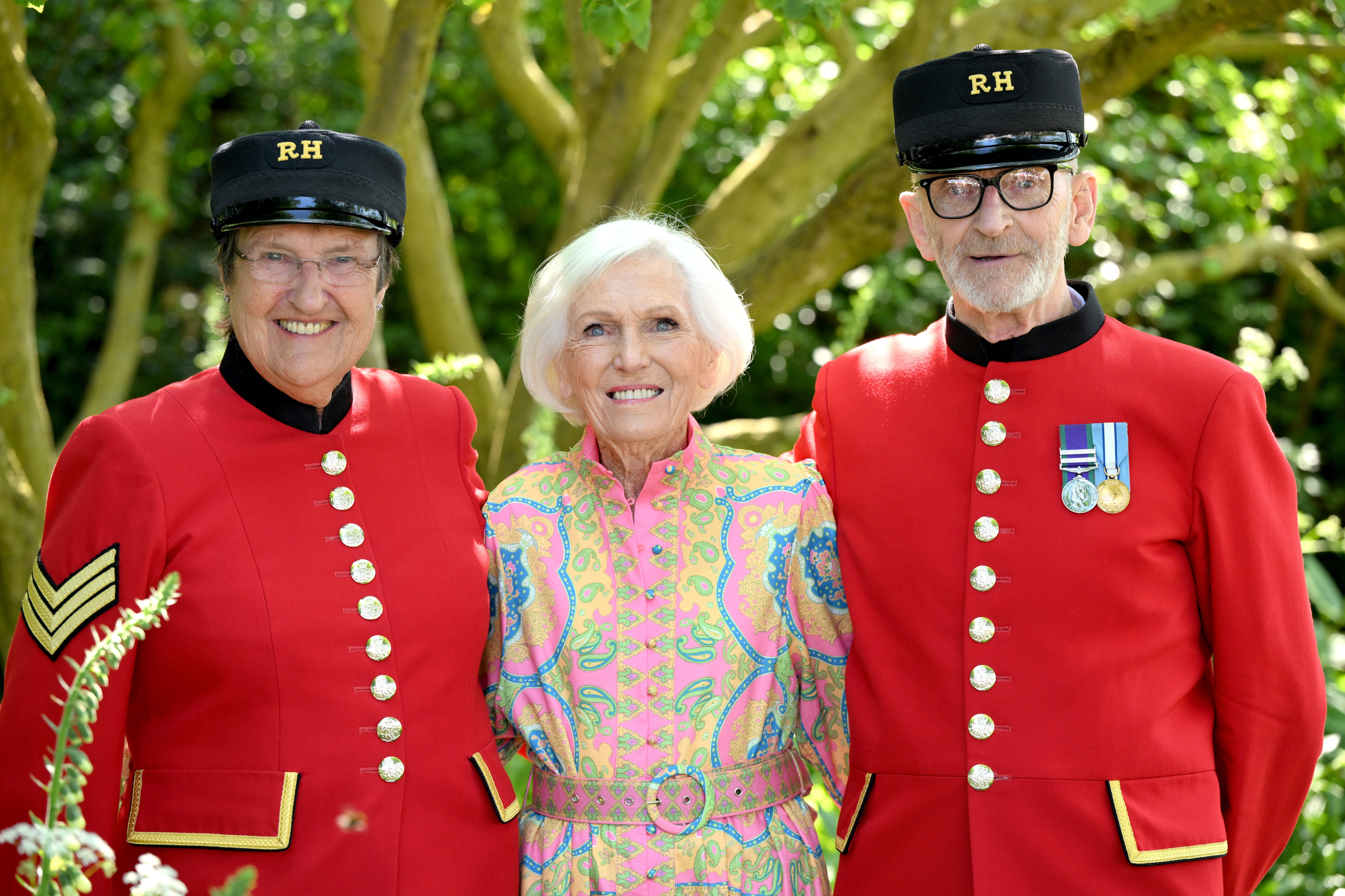 President of the National Garden Scheme Dame Mary Berry poses with two Chelsea pensioners as they attend The RHS Chelsea Flower Show