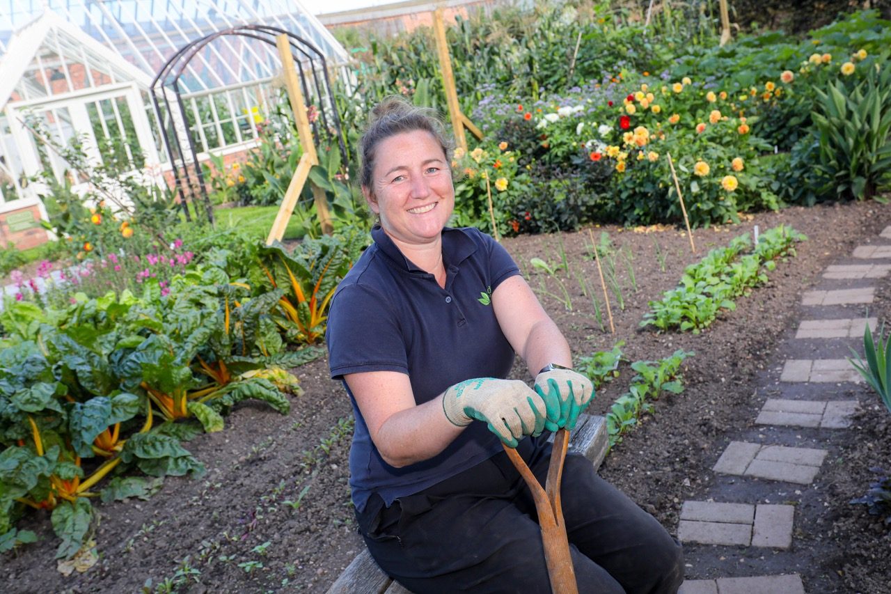 Garden Organic head gardener Emma O'Neill sat in veg bed