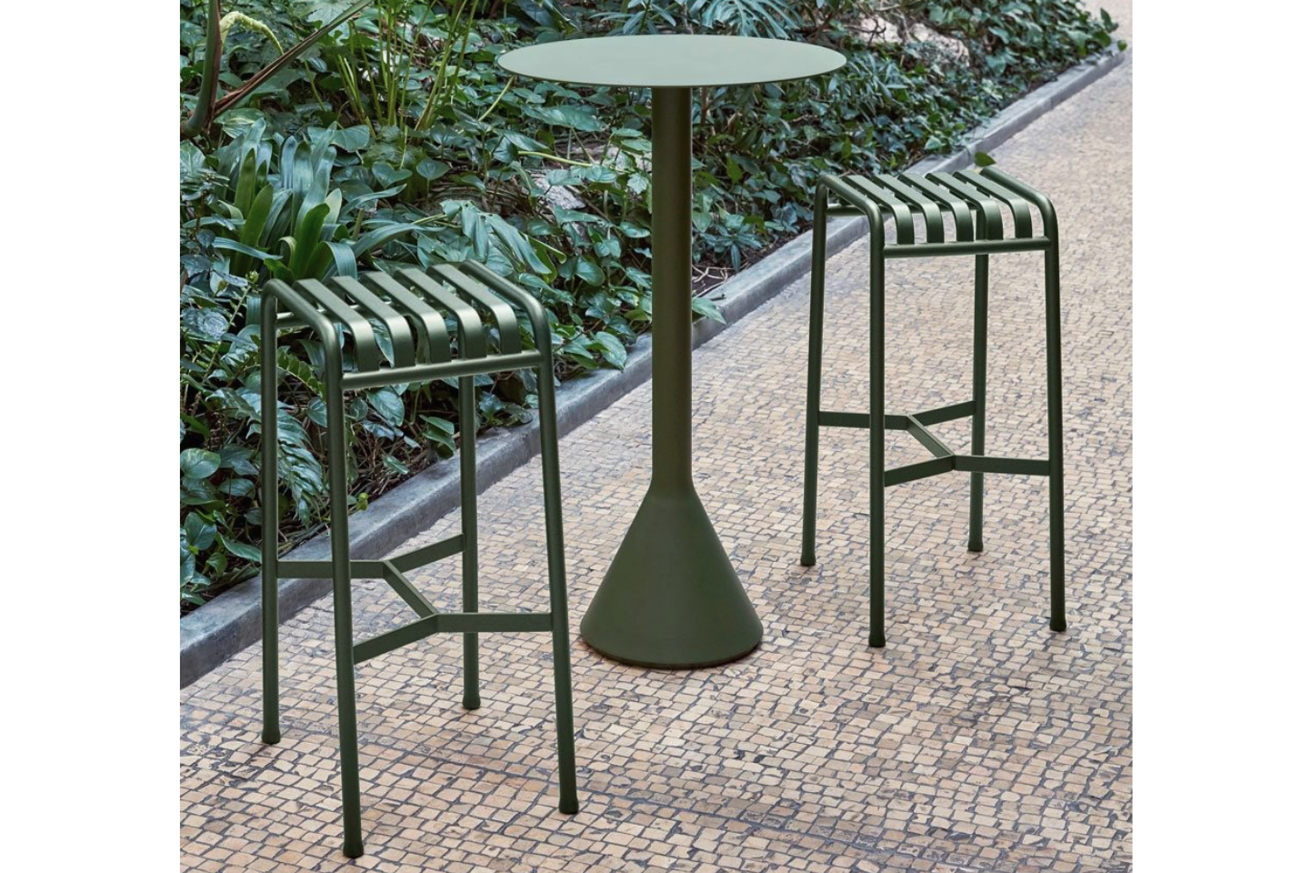 Hay Palissade Bar Stool and Cone Table in Olive on a paved path