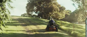 Man on ride on mower in field Man on ride on mower in field