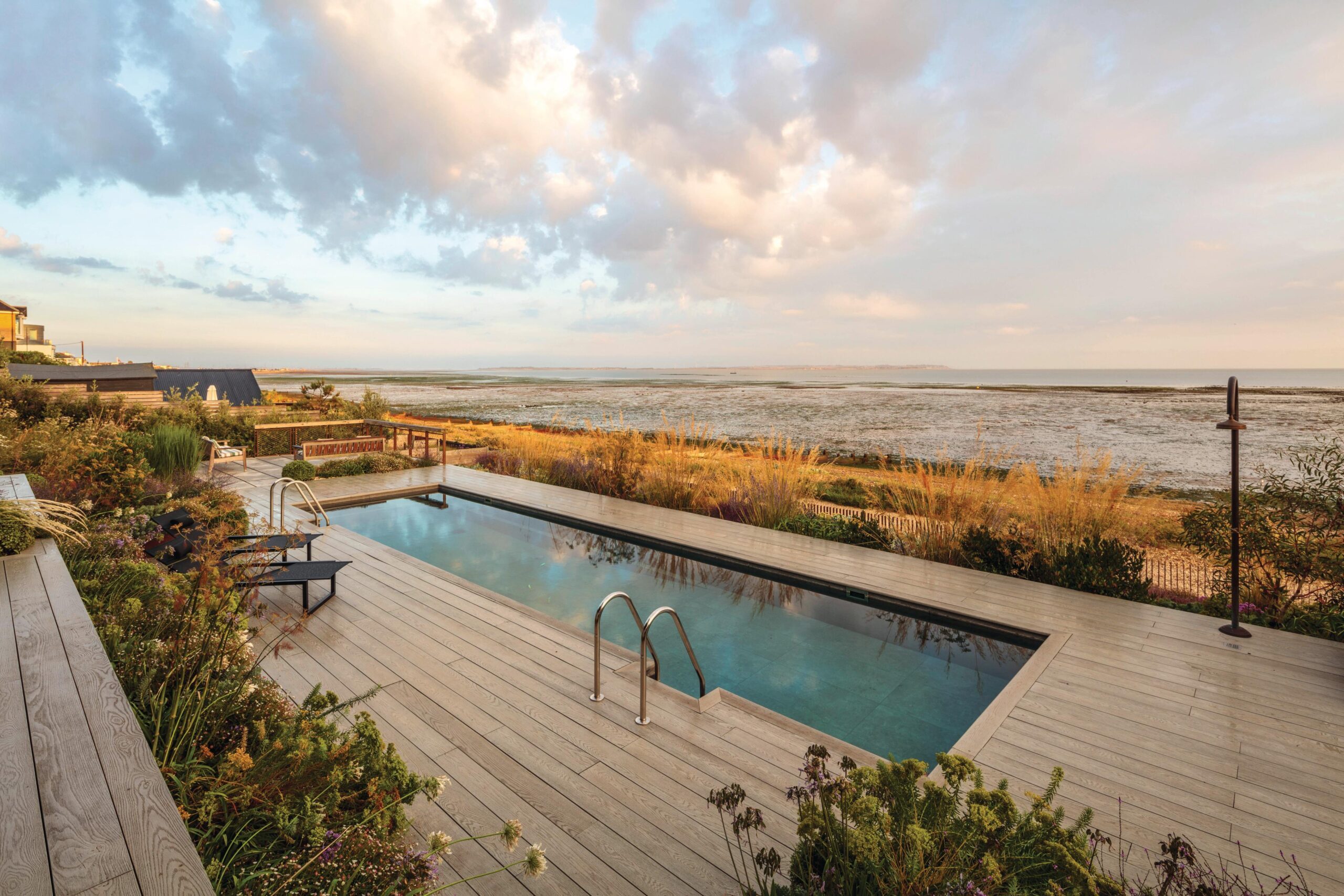 The feathery foliage and delicate flowerheads of fennel (Foeniculum vulgare) add another texture to the planting around the swimming pool, where the water acts as a giant mirror to the sky, reflecting the clouds and the sunset.