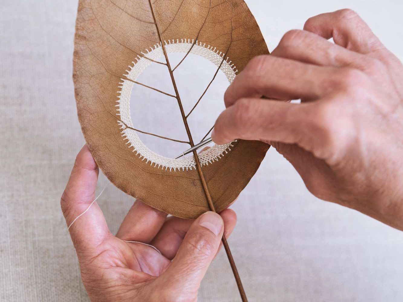 Artist working on a crocheted leaf
