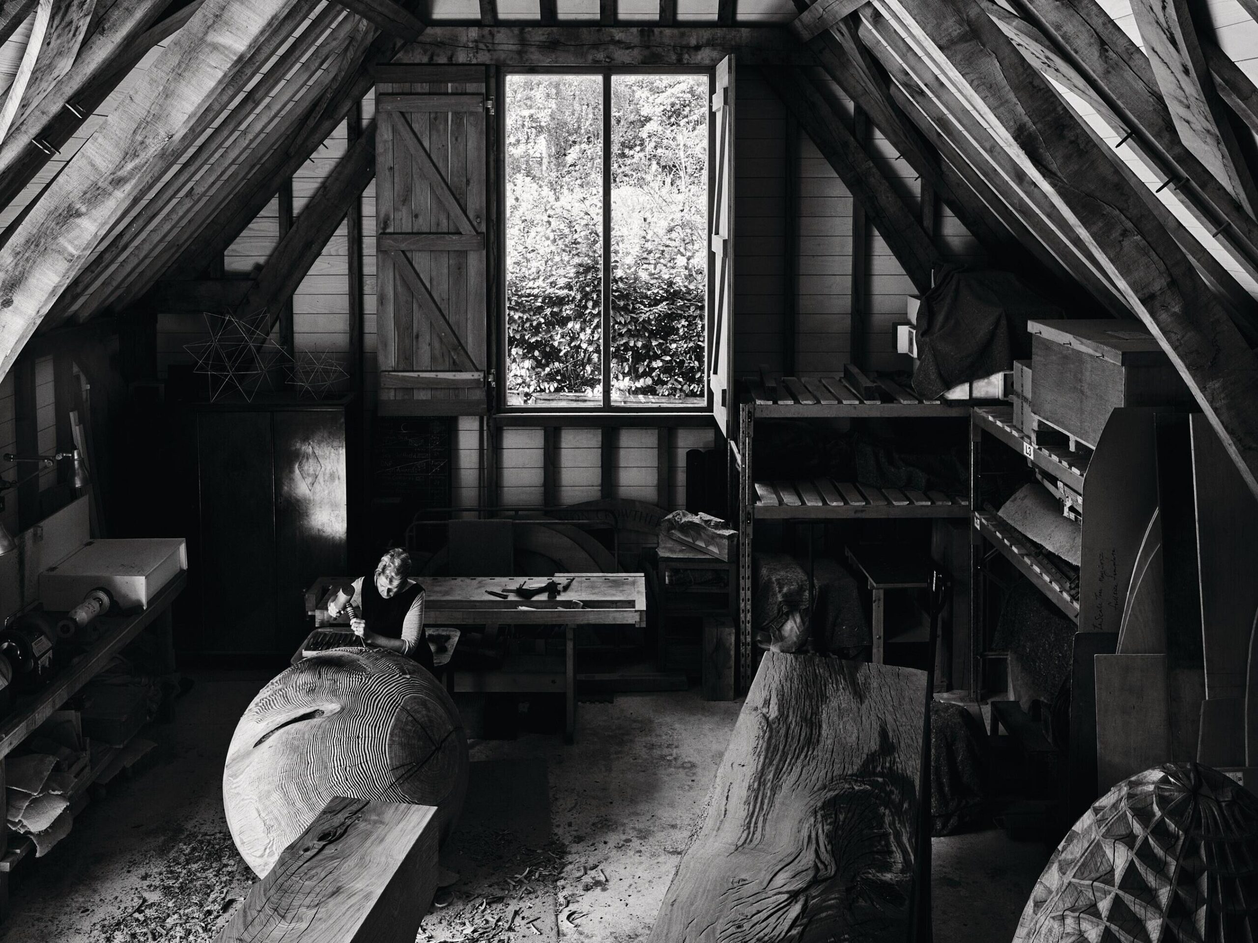 Woman in studio sculpting with wood