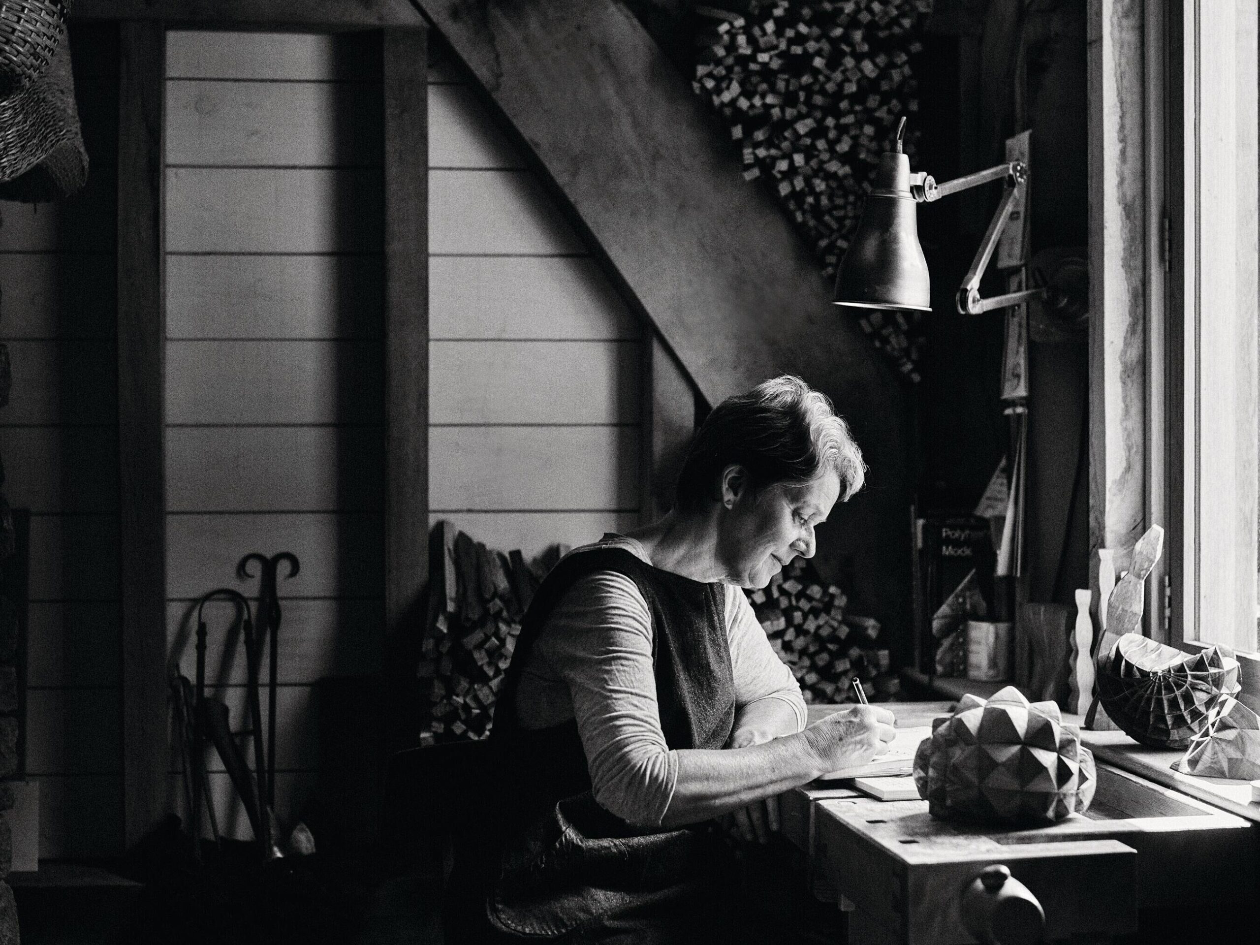 Woman sitting at desk drawing in studio