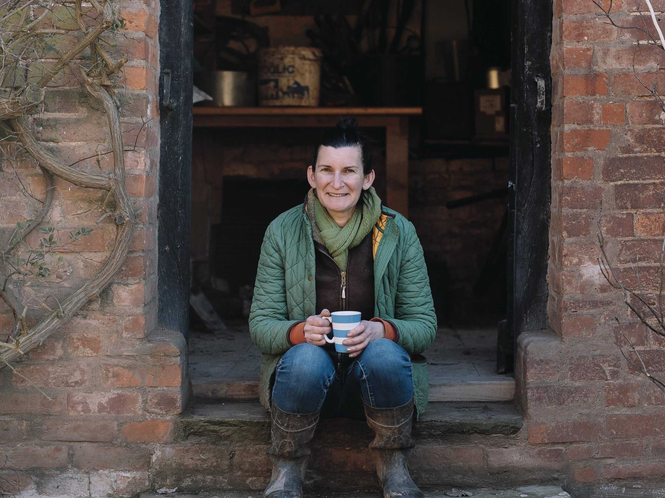 Woman sat on steps holding a mug