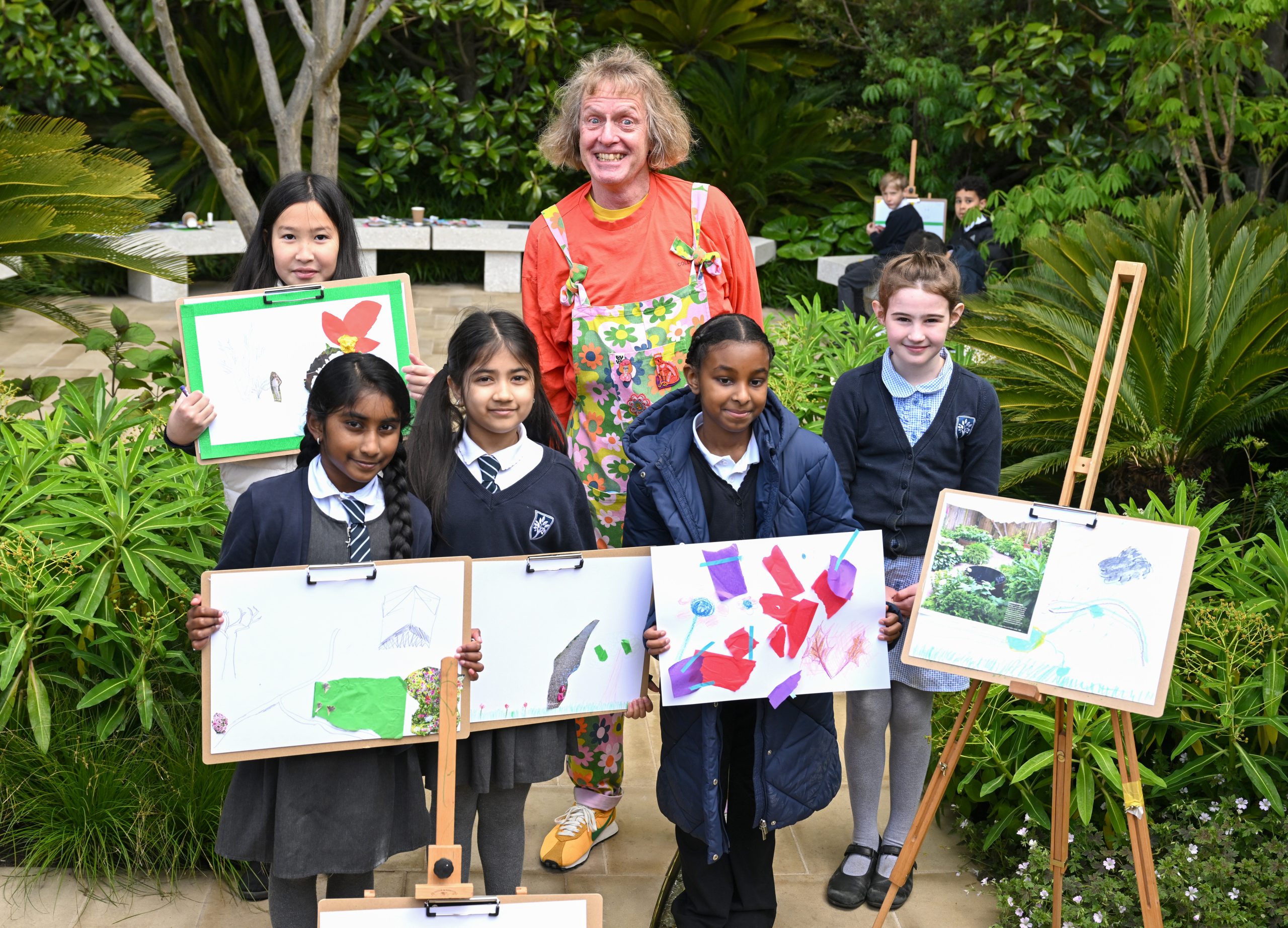 Grayson Perry poses with local school children and their art work as they attend the RHS Chelsea Flower Show 2026 © Jeff Spicer/Getty Images
