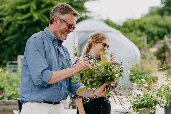 Two people arranging flowers