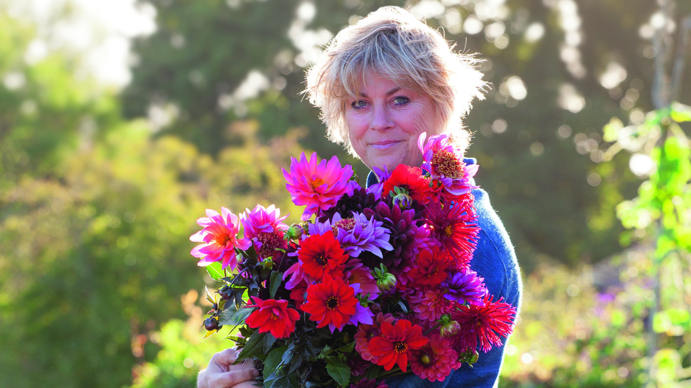 Sarah Raven carrying a bunch of dahlias