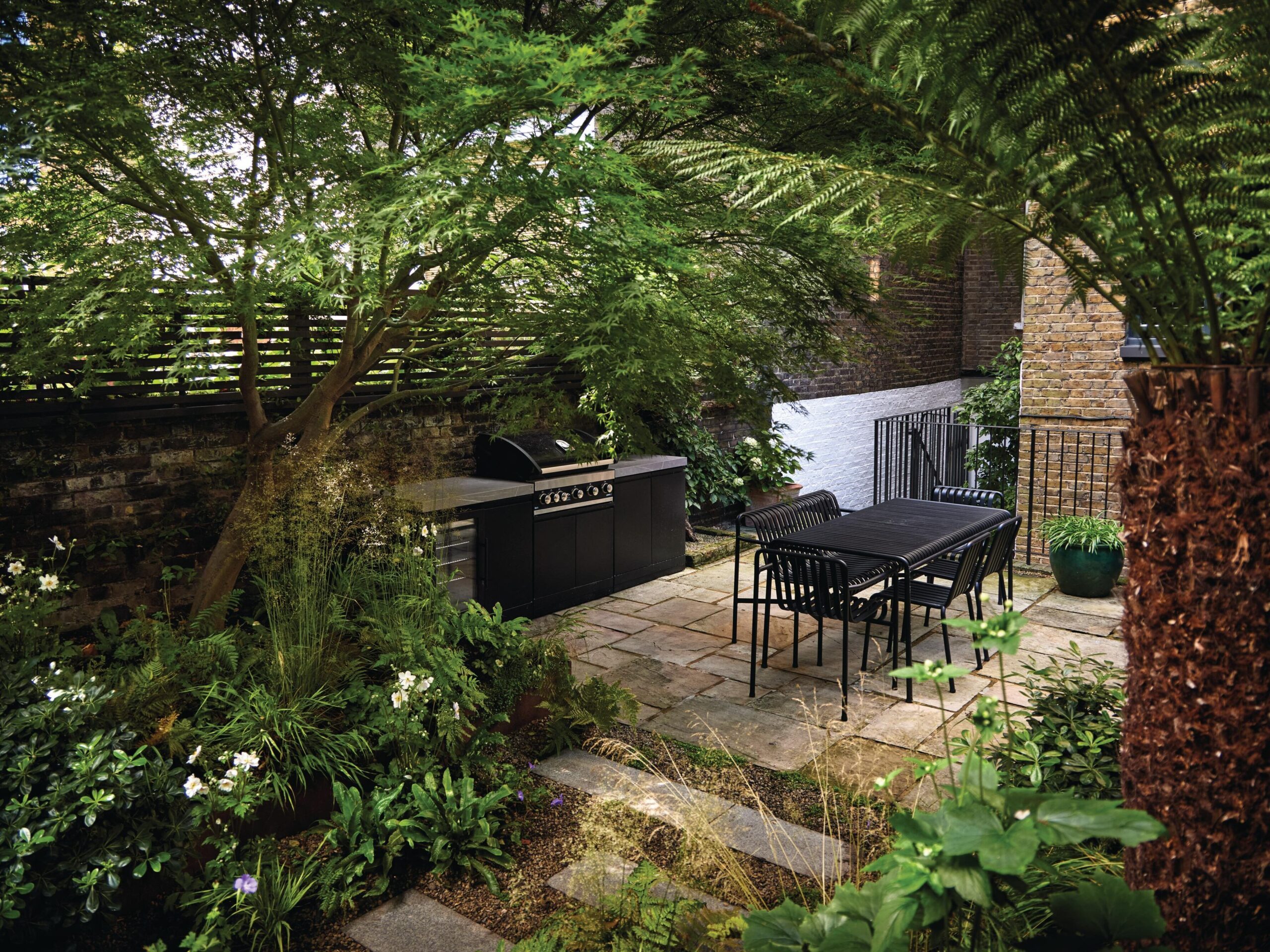 Paved garden seating area with BBQ