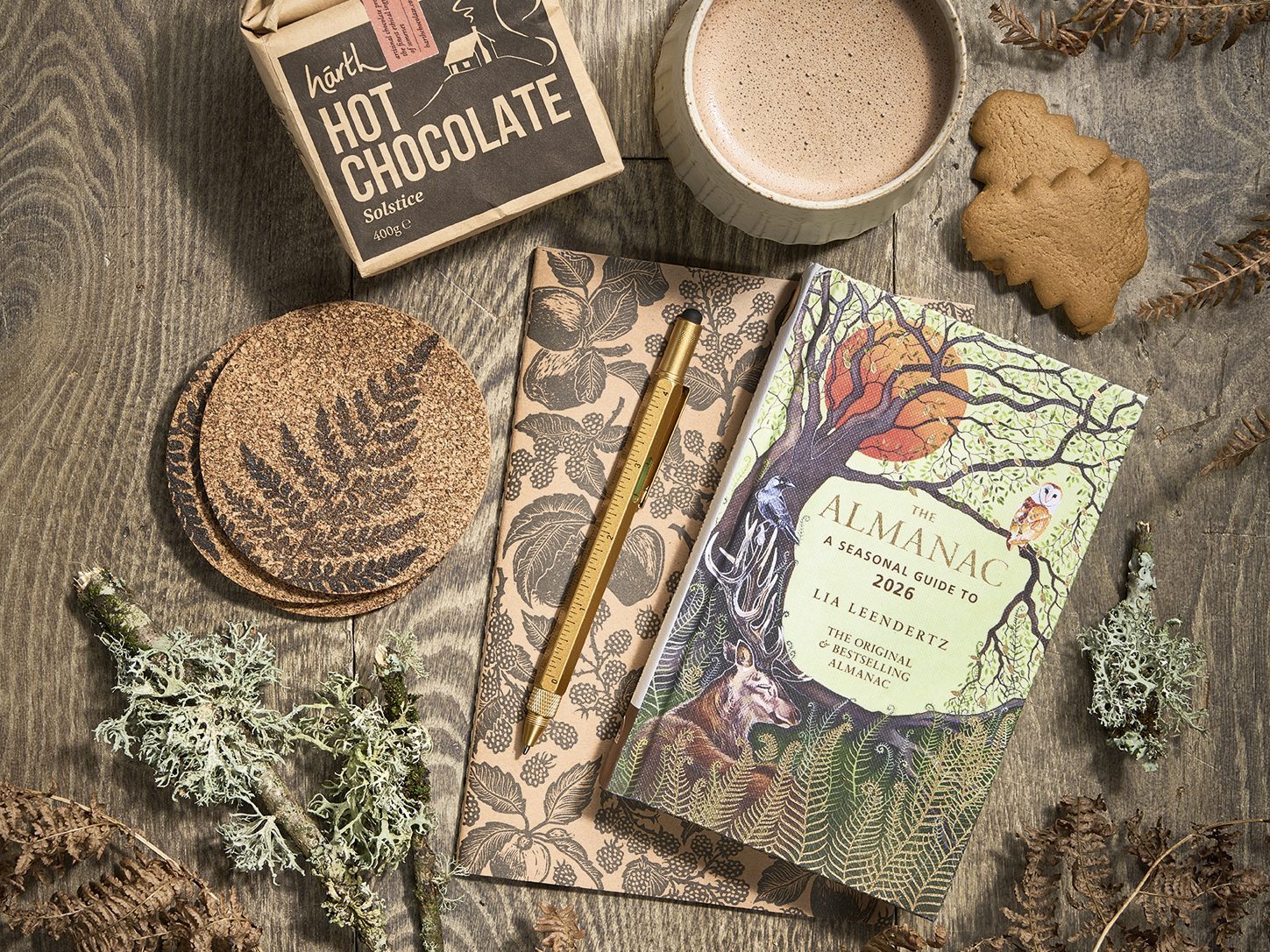 The best gifts for gardeners - Solstice Hot Chocolate, 400g, £8.95, Harth; Bel Holland Fluted Mug, large, £34, The Painted Bird; Gingerbread Christmas Tree Biscuits, 125g box, £3.50, Hawkens Gingerbread; Beth Lewis Linoprint Apple Orchard Notebook, black, A5 plain paper, £6, and Beth Lewis Fern Coasters, black, £12 for four, both These Two Hands; The Almanac: A Seasonal Guide To 2026, by Lia Leendertz, published by Octopus Books £12.99, Waterstones; Workshop Pen, multi-tool, £12, Plümo.