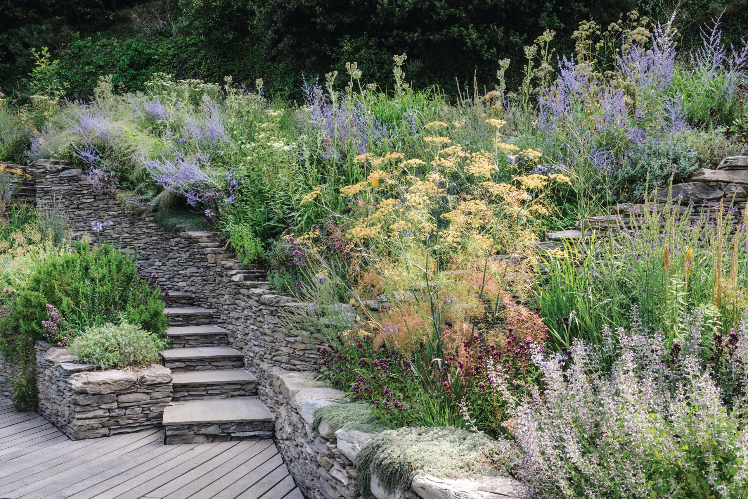 Stone quarried on-site for the dry-stone walls and steps is used to create a strong bond with the landscape. The walls also heat up and warm the garden, extending the seasons and creating a microclimate.