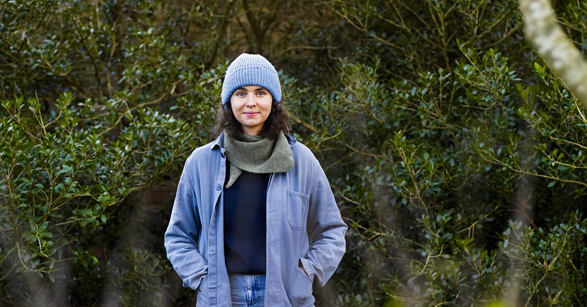 Hannah Moore © Andrew Montgomery Woman with green bushes in the background