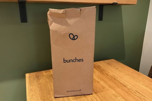 Bunches flower delivery packaging on a wooden table