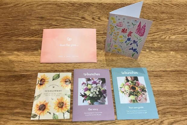 Bunches flower delivery guides and card on a wooden table