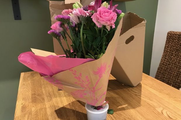 Bunches flower delivery packaging on a wooden table