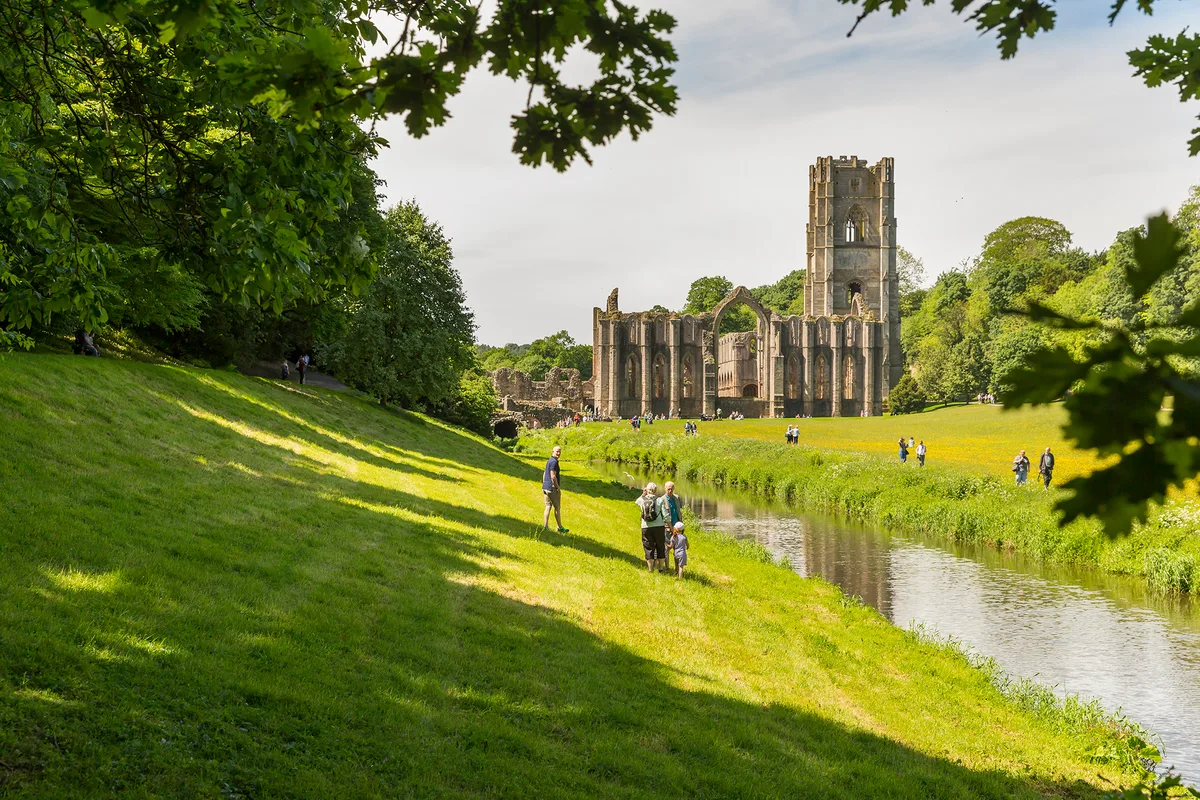 Visitors walking through the grounds of Fountains Abbey Visitors walking through the grounds of Fountains Abbey