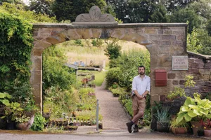 Dean Charlton at Hooton's Walled Nursery Man stood under garden stone archway