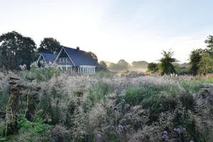 Hans Giezen garden and home House and garden set against blue sky