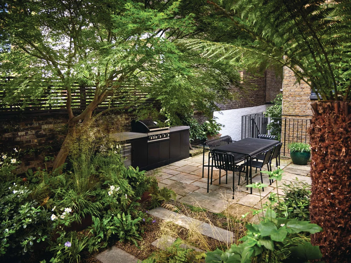 This small London garden designed by Harry Holding makes room for a stylish outdoor kitchen © Alister Thorpe Courtyard garden with dining table and chairs