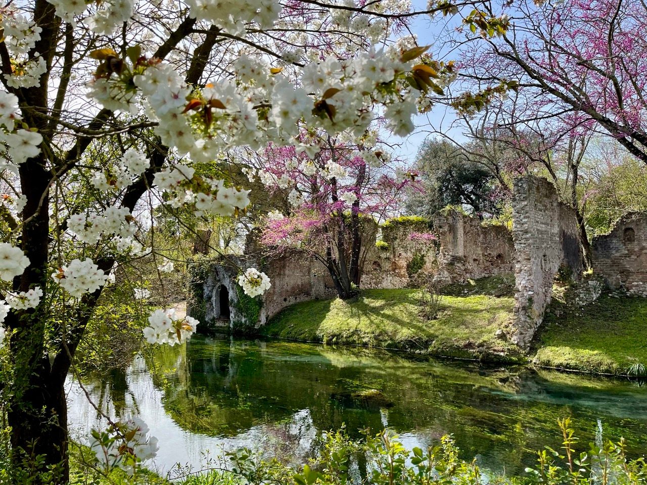 A riverside view showcases vibrant blossom at Giardino di Ninfa. Credit: Archivio Fondazione Roffredo Caetani