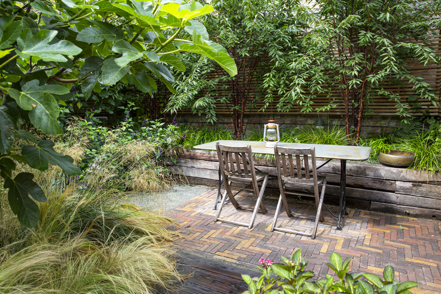 A raised bed made of old railway sleepers in a London garden designed by Ula Maria