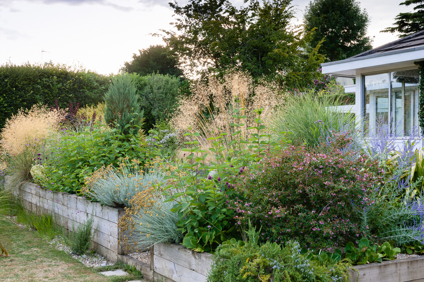 Raised beds of oak landscape sleepers in a Dorset garden designed by Alice Meacham