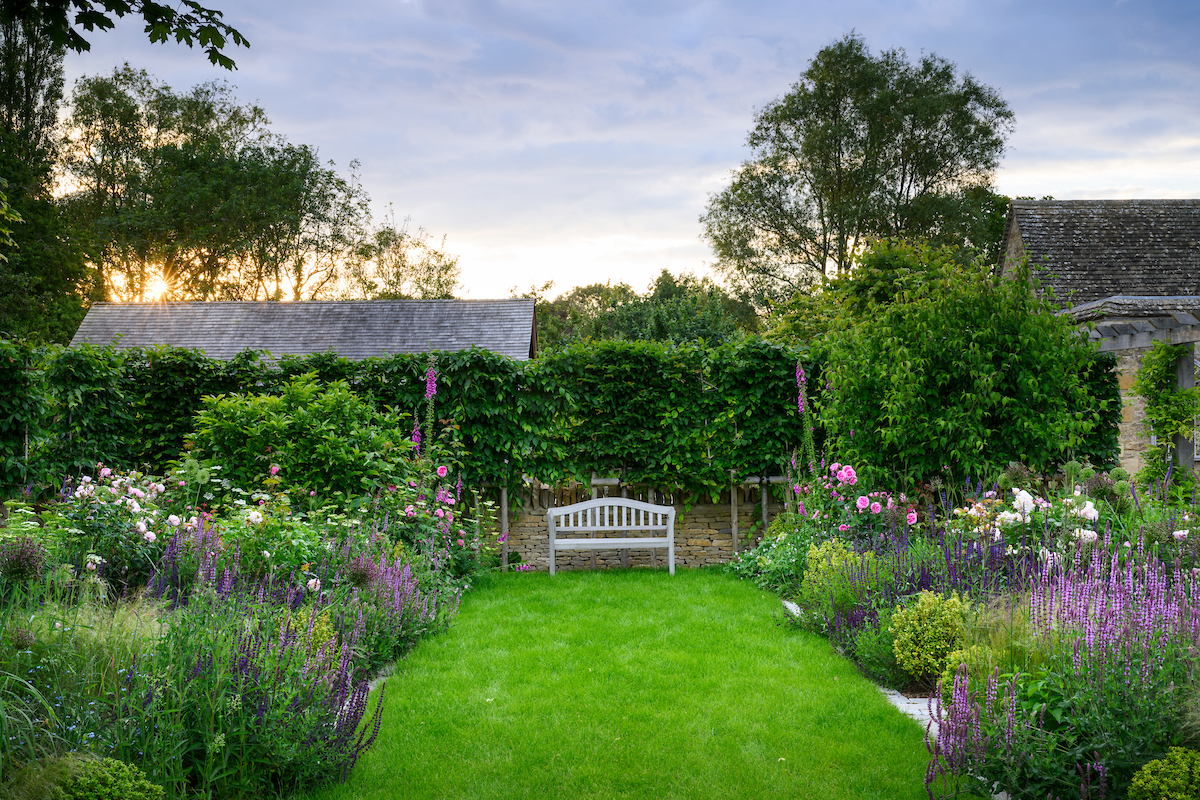 A bench forms a central focal point in this pleasingly symmetrical Cotswolds garden