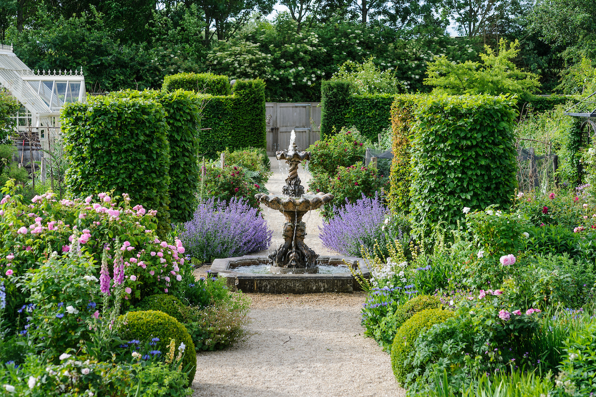 This contemporary water feature contrasts with lush planting in a private Oxford garden