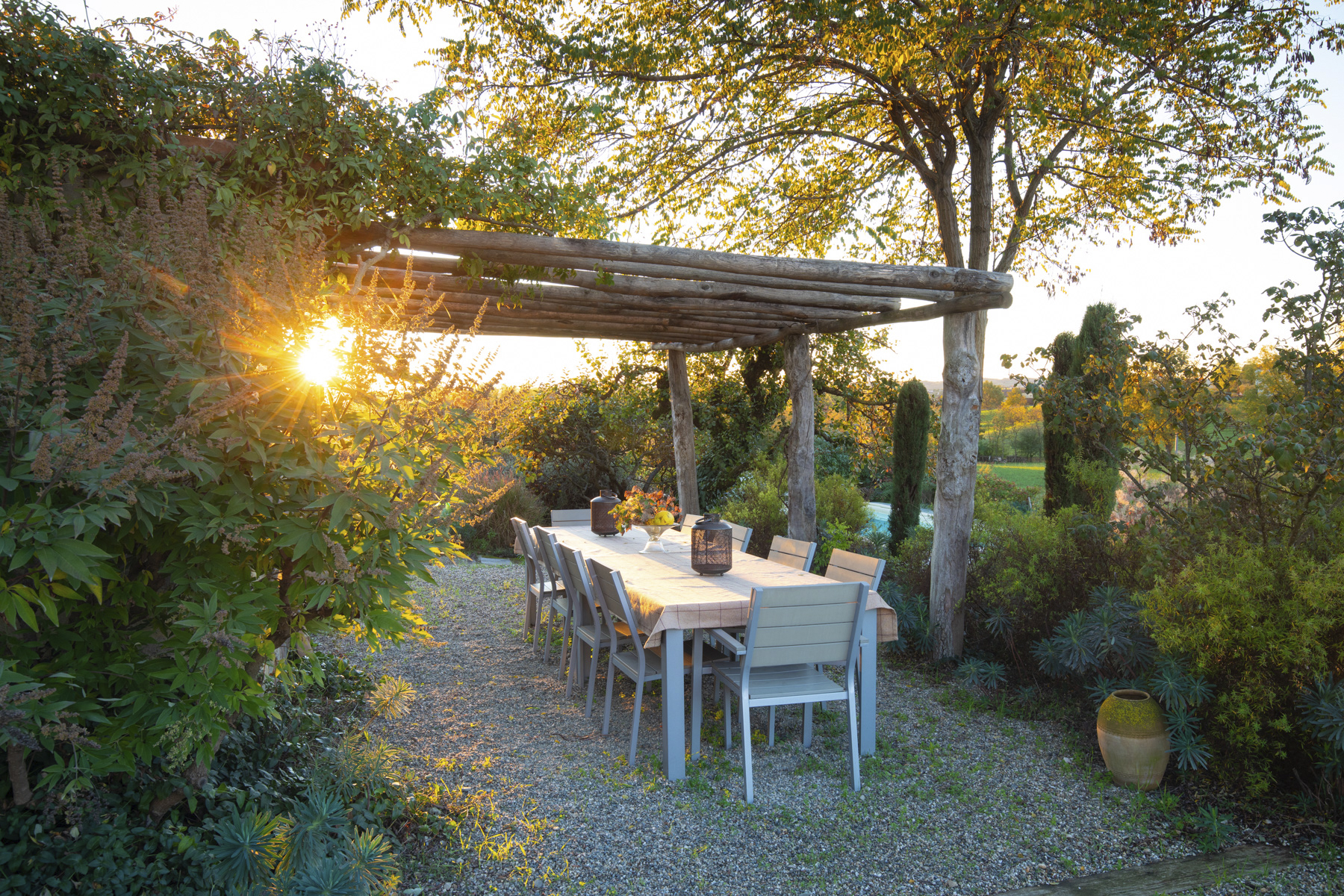 Designer Cristina Mazzucchelli’s garden in Italy has a stylish outdoor dining zone, covered with a rustic pergola